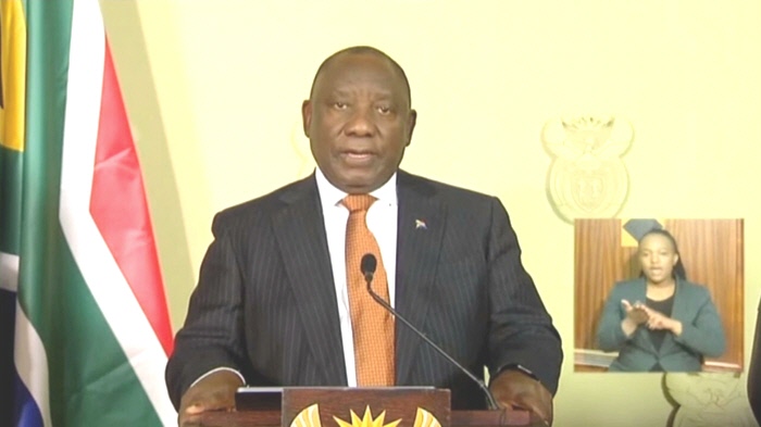 President Cyril Ramaphosa at his desk with the SOuth African flag in the background and a SASL interpreter in the bottom right corner